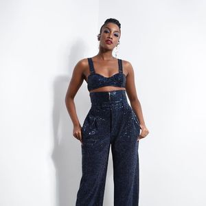 O look de Iza: conjuntinho de top e calça cheio de brilho e um sapato na cor branca.