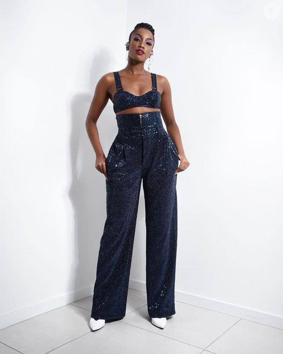 O look de Iza: conjuntinho de top e calça cheio de brilho e um sapato na cor branca.