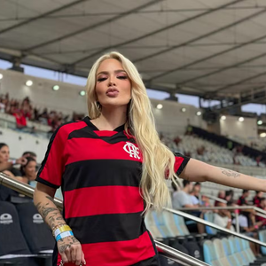 Karoline Lima pode servir de inspiração para quem deseja combinar o New Balance 9060 Preto Vermelho com a camisa do Flamengo. A mistura entre o sneaker de visual esportivo e a peça que representa o clube é uma possibilidade para montar uma produção casual com as cores rubro-negras