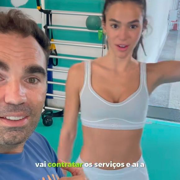 O visual é composto por sutiã esportivo e legging em tom azul acinzentado, com costuras contrastantes que valorizam a silhueta de forma estratégica.