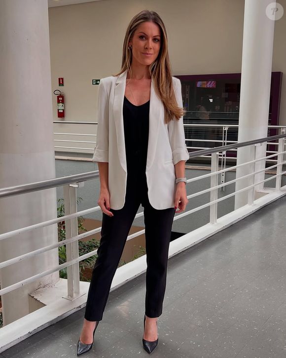 Jacqueline Brazil usou para apresentar o 'Jornal Hoje' um blazer branco com o restante do look todo preto, inclusive sapato.