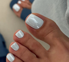 Os tons de branco com finalização brilhosa dão efeito elegante à pedicure