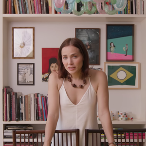 Mesa de jantar de Letícia Colin fica logo em frente a uma estante com centenas de livros da coleção da atriz