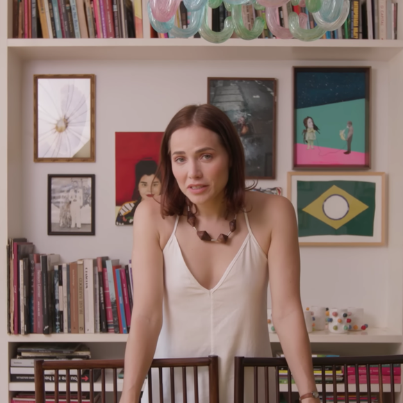 Mesa de jantar de Letícia Colin fica logo em frente a uma estante com centenas de livros da coleção da atriz