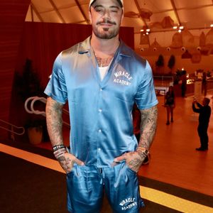 Felipe Titto escolheu um conjunto coordenado em cetim azul-turquesa com acabamento acetinado, composto por camisa de manga curta com gola bowling e bermuda com estampa Miracle Academy. Ele arrematou o visual sportswear com boné aba curva dos New York Yankees, meias altas e tênis casual