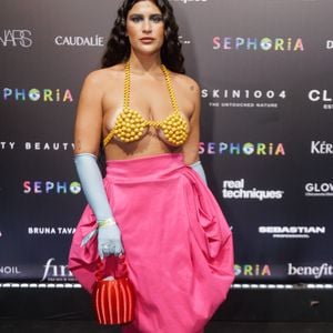 Giulia Costa vestiu um look que é uma mistura ousada de elementos: um 'top-sutiã' feito inteiramente de esferas amarelas tridimensionais, uma saia volumosa rosa choque em estilo balão e cintura alta, luvas azul-bebê e sapatos vermelhos de pelúcia, resultando em uma das produções mais artísticas e coloridas da noite!