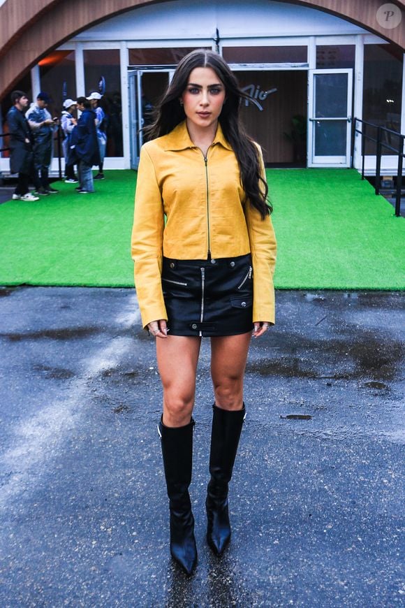 Jade Picon apostou no contraste entre amarelo e preto. A jaqueta amarela de couro foi combinada com uma minissaia preta de efeito envernizado e botas pretas de cano alto