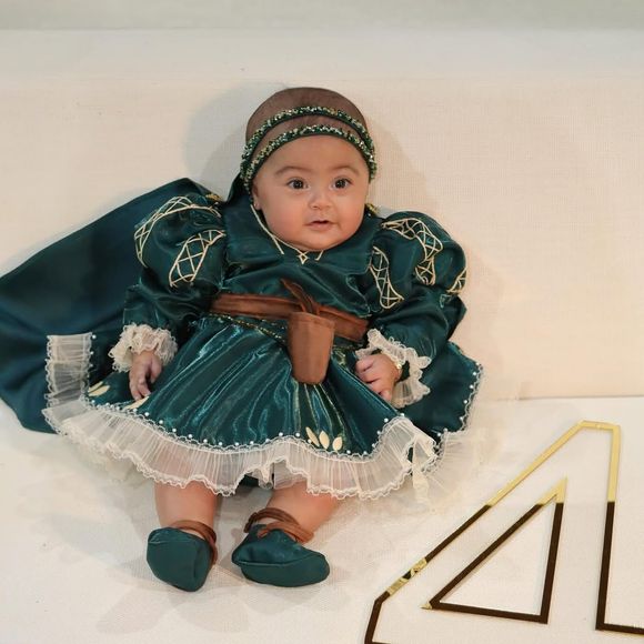 A pequena posa ao lado do número 4, celebrando seu quarto mês de vida
