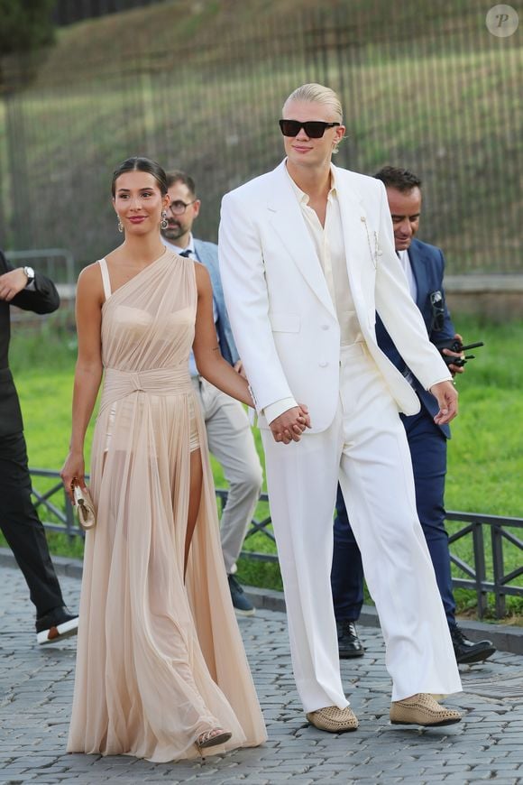 O estilo de Erling Haaland ao lado da esposa Isabel Haugseng Johansen nas férias ganhou destaque com uma sandália preta de couro, modelo versátil que prova que conforto e sofisticação podem caminhar juntos e que pode ser usado até com terno de linho
