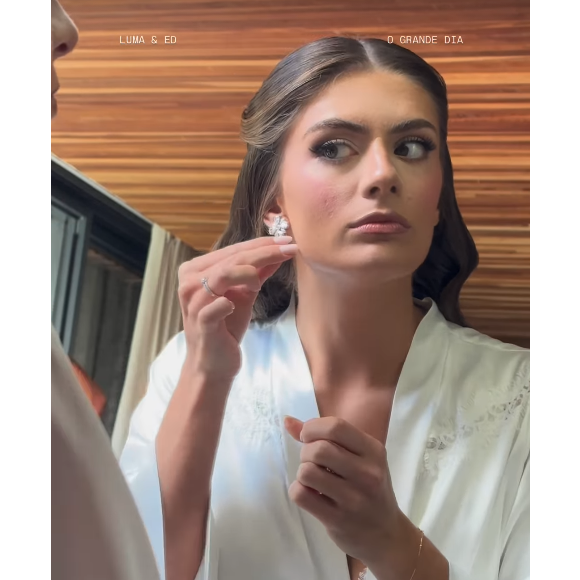 Luma César completou o look com um par de brincos brilhantes e um buquê de lírios da paz brancos