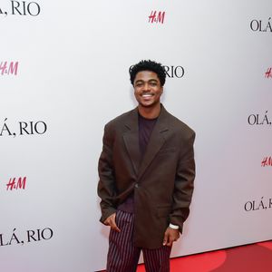 Guthierry Sotero: o ator investiu em um visual de proporções amplas e tons terrosos. A peça central é um blazer oversized marrom de abotoamento simples, usado sobre uma camiseta em tom de berinjela escuro. A parte inferior traz uma calça de alfaiataria com padronagem risca de giz em tons de vinho e cinza, com modelagem solta