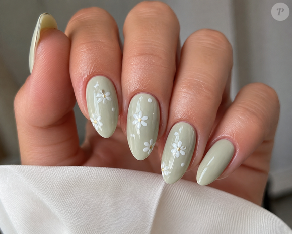 O verde pastel também pode aparecer em uma versão delicada e sofisticada. Como base para pequenas flores brancas, o tom cria uma manicure romântica, discreta e perfeita para quem quer acrescentar um detalhe diferente às mãos