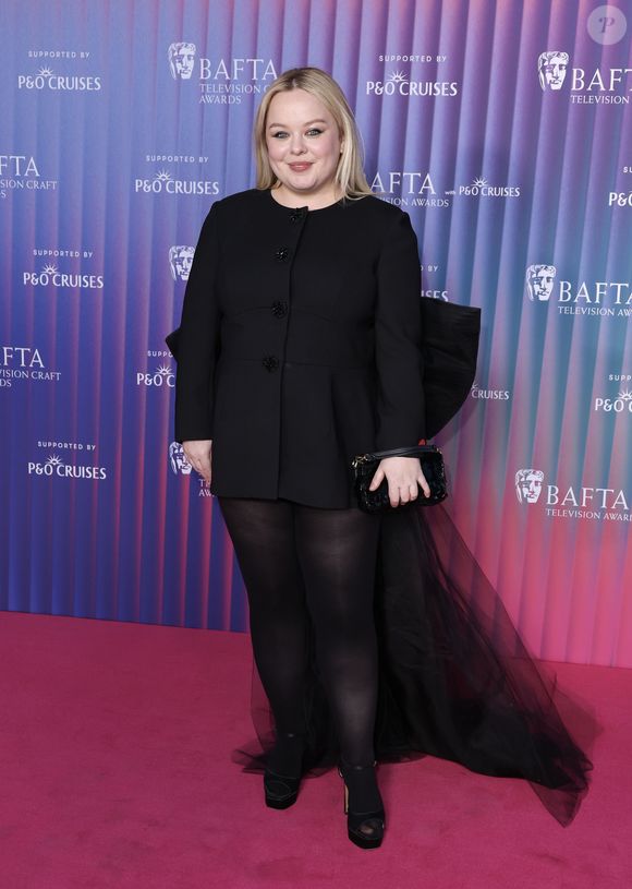 A estrela de "Bridgerton" usava um minivestido peplum preto com botões na frente e um laço enorme e cauda de tule nas costas.