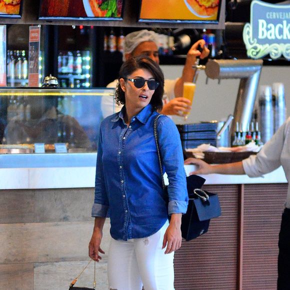 Para embarcar, Juliana Paes usou blusão jeans, calça branca e mocassim