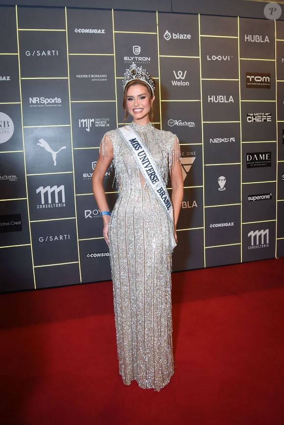 Marcela Porto (Miss Universe Brasil): trajou um vestido longo prateado inteiramente trabalhado em pedrarias brilhantes e franjas nas mangas curtas e decote, complementado pela faixa de Miss e coroação oficial