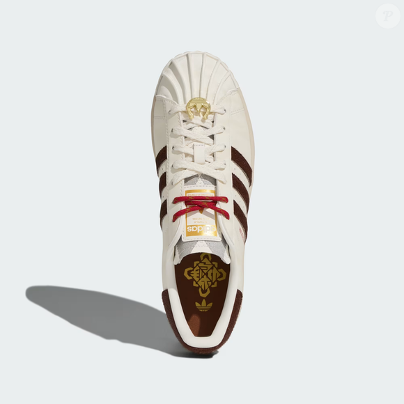 O sneaker ganha detalhes exclusivos que reforçam a temática: o destaque fica por conta do dubre no cadarço, que combina o formato de uma ferradura com o clássico logotipo Trefoil, criando uma conexão direta com o universo do Cavalo.