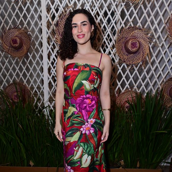 Livian Aragão: destacou-se em um vestido longo de alças finas com uma estampa tropical vibrante de folhagens verdes e flores em tons de rosa, roxo e vermelho sobre fundo escuro. A atriz completou o visual de frescor estivo com sandálias de tiras marrons e brincos dourados
