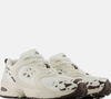 O New Balance 530 combina elementos clássicos e detalhes de aparência tecnológica. O cabedal apresenta uma construção com mesh e sobreposições sintéticas, além de curvas e ângulos que reforçam a identidade visual do modelo.