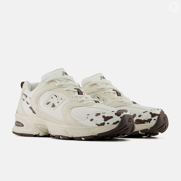 O New Balance 530 combina elementos clássicos e detalhes de aparência tecnológica. O cabedal apresenta uma construção com mesh e sobreposições sintéticas, além de curvas e ângulos que reforçam a identidade visual do modelo.
