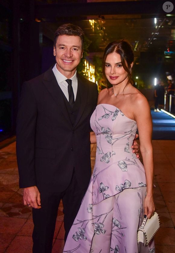 Vera Viel surgiu com um look que une romantismo e construção sofisticada. A apresentadora escolheu um vestido tomara que caia lilás-claro, pontuado por estampa floral preta delicada. O decote coração e os recortes assimétricos na saia deram movimento à produção, que brinca com volumes em perfeita harmonia