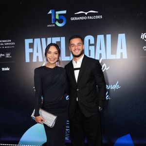 Philippe Coutinho e esposa Ainê Coutinho: ela vestiu um vestido preto longo de mangas compridas, com decote canoa e detalhes drapeados na cintura e finalizou o look com uma clutch prateada texturizada e sandálias pretas de salto alto. Ele usava um terno preto clássico, camisa branca de botões e sapatos sociais pretos