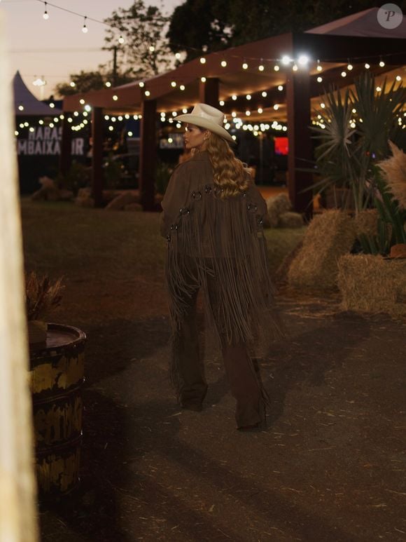Andressa Suita escolhe look em tons terrosos, com franjas, cinto western e chapéu branco, para assistir ao rodeio em Barretos