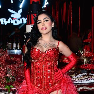 Mirella surgiu com body vermelho cravejado de pedrarias, luvas longas e meias arrastão combinando, além de um exuberante robe de plumas