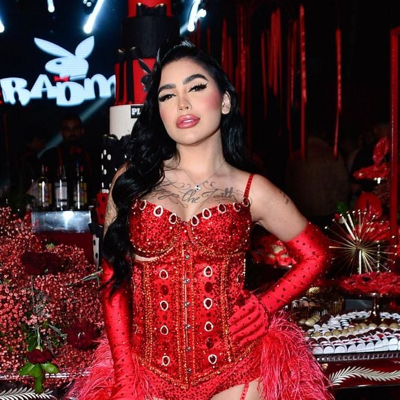 Mirella surgiu com body vermelho cravejado de pedrarias, luvas longas e meias arrastão combinando, além de um exuberante robe de plumas
