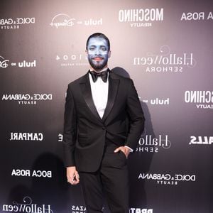 Raider Cadete: o terno clássico estilo smoking preto possui lapela xale em cetim, combinado com camisa social branca, gravata borboleta preta e botas de couro preto. O elemento surpreendente da produção fica por conta da caracterização facial total. O rosto está coberto por pintura corporal artística em tons de azul e branco, cobrindo bochechas, testa e barba