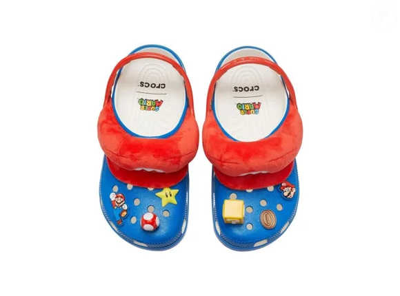 O Mario Classic Clog acompanha 6 Jibbitz exclusivos, incluindo dois do próprio Mario, além de referências como Super Estrela, Super Cogumelo, moeda e Bloco de Interrogação (?), permitindo personalizar o calçado de acordo com a proposta da coleção