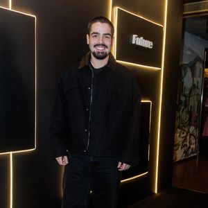 Filho de Faustão, João Guilherme Silva aposta em uma estética urbana e minimalista com uma proposta inteiramente voltada para tons escuros. Ele veste uma jaqueta de sarja preta estruturada, de modelagem ampla estilo oversized, caracterizada por lapelas proeminentes e fechamento em zíper frontal. Por baixo, complementa com uma camiseta básica preta de gola careca. A parte inferior é composta por uma calça jeans preta de corte reto e lavagem discreta