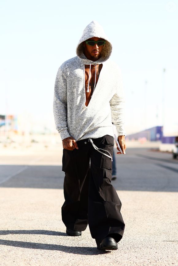 Lewis Hamilton chega aos autódromos como se estivesse desfilando para uma maison parisiense, usando looks de marcas como Louis Vuitton, Balenciaga, Rick Owens, Valentino e Dior.