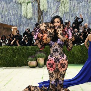 Cardi B marcou presença com um 'bodyland' conceitual que explorou transparências e volumes arquitetônicos. O macacão de renda preta sobre um fundo nude foi adornado com estruturas acolchoadas circulares que envolviam os ombros e a base das pernas, criando um efeito visual de 'nuvem' texturizada que desafiava as proporções tradicionais do corpo