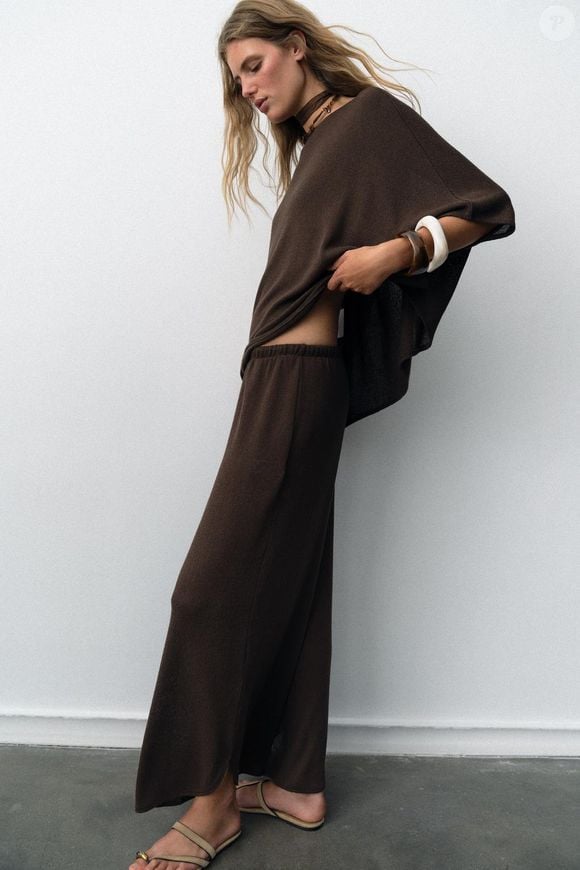 Quem procura uma alternativa para variar os looks da Primavera 2026 pode encontrar na Zara uma calça rústica com cintura alta, cós elástico e pernas largas. Por R$ 179, a peça tem aberturas laterais que reforçam sua proposta boho-chic e permitem explorar combinações com diferentes estilos de blusas e calçados