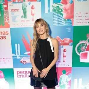 Vestido preto, botas de couro e acessórios Louis Vuitton marcaram o visual de Carolina Dieckmmann em noite de cinema