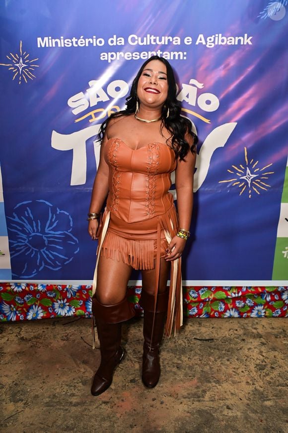 Ex-BBB Chaiany escolheu um lok de couro todo marrom com franjas na saia para o evento e combinou com uma bota escura