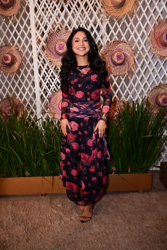 Mileide Mihaile: apostou na estampa floral clássica com um vestido midi de fundo preto e padronagem de rosas vermelhas com folhagens. A peça possui mangas longas em tecido levemente transparente, gola fechada e uma faixa drapeada na cintura, finalizada com sandálias pretas de tiras finas