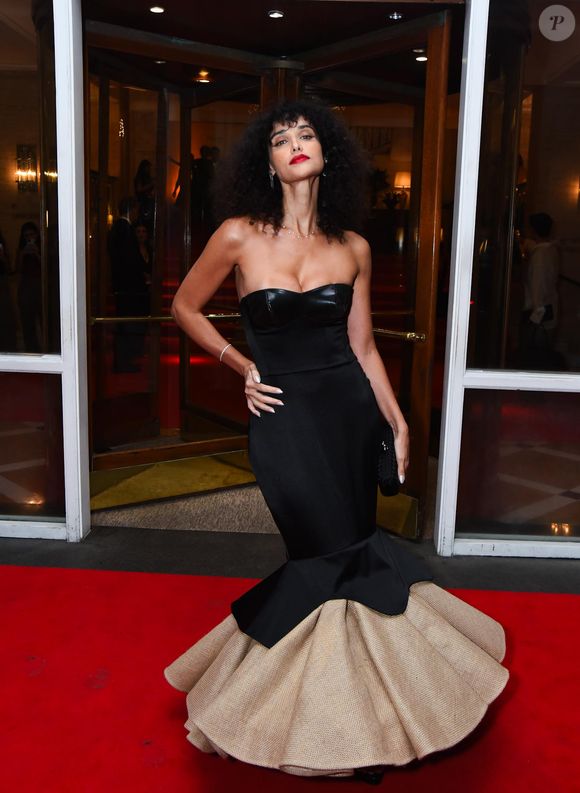 Débora Nascimento: atriz utiliza um vestido longo de silhueta sereia com um design dramático e vanguardista. O corpo da peça é um tomara-que-caia preto com detalhe em couro no busto, que se ajusta até a altura dos joelhos. A partir daí, a saia se abre em um volume escultural de camadas duplas: a superior em tecido preto liso e a inferior em um material de textura rústica e cor areia, criando um contraste de tons e formas