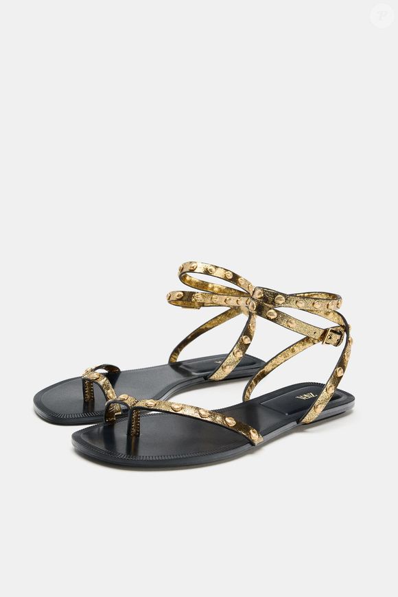 Toque orgânico em evidência! A sandália rasteira da Zara de R$ 279 chega com acabamento laminado e tiras delicadas com tachas metálicas em formato de conchas, unindo sofisticação e estética natural no mesmo design