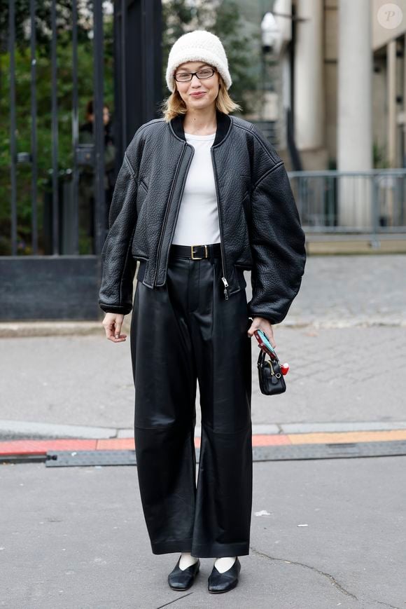 A modelo Gigi Hadid opta por um visual black and whit composto por calça, jaqueta e camisa branca além de gorro, no estilo street style, durante a Semana de Moda de Paris 2025.