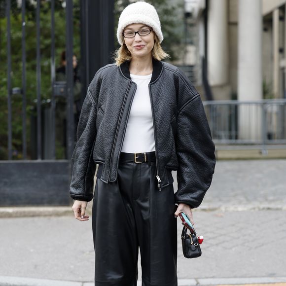 A modelo Gigi Hadid opta por um visual black and whit composto por calça, jaqueta e camisa branca além de gorro, no estilo street style, durante a Semana de Moda de Paris 2025.