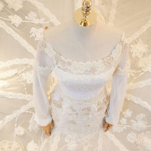 Já o corpo do vestido, um modelo ombro a ombro bordado à mão, traz leveza e elegância ao visual.