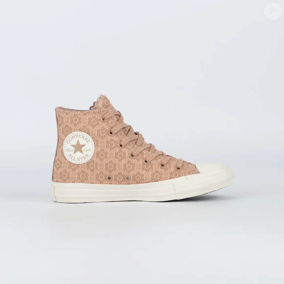 O clássico Converse Chuck Taylor All Star ganha uma versão renovada com estética boho-chic, em tom café com leite amêndoa e sobreposição de renda floral que reforça a proposta artesanal do modelo