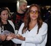 Anitta foi flagrada atendendo fãs no aeroporto, enquanto o novo namorado da cantora aparecia ao fundo