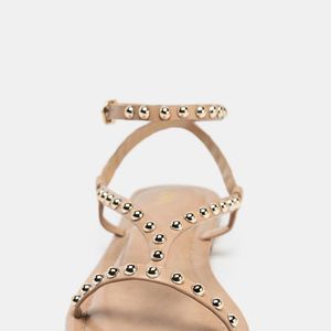 Com pegada boho chic repaginada, a sandália da Zara de R$ 319 surge em tom bege neutro e traz tiras conectadas ao tornozelo, além de bico redondo e fechamento com fivela metálica para mais conforto
