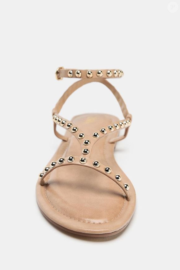 Com pegada boho chic repaginada, a sandália da Zara de R$ 319 surge em tom bege neutro e traz tiras conectadas ao tornozelo, além de bico redondo e fechamento com fivela metálica para mais conforto