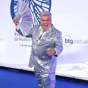 Milton Cunha: Visual maximalista e festivo composto por um terno inteiramente coberto de paetês brilhantes em tom azul-escuro metalizado com lapelas clássicas pretas. A peça foi combinada com uma camisa preta por baixo e um broche de pedrarias prateadas na lapela