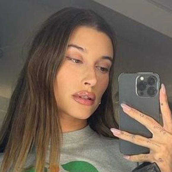 Hailey Bieber aposta em esfumado com os dedos para deixar o contorno dos lábios mais suave e com acabamento natural