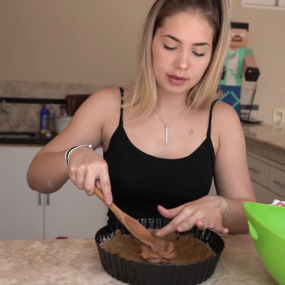 Com a metade da massa na forma, coloque uma camada generosa de doce de leite, que servirá como recheio