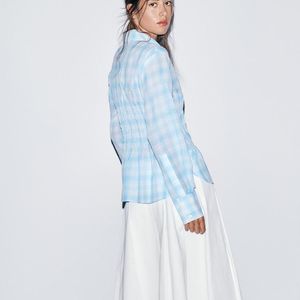 O design clean e as pregas estruturadas transformam a saia midi da Zara em uma escolha atemporal para mulheres elegantes